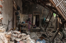 A villager looks for her belongings at her damage house in Pandeglang, Banten province on August 3, 2019, after a strong earthquake hit the area. - Indonesian authorities lifted a tsunami warning after a powerful 6.9 magnitude earthquake earlier struck off the southern coast of heavily populated Java island. (Photo by SAMMY / AFP)