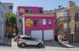 View of the pink emoji house that has become embroiled in a feud between neighbors in Manhatten Beach, California on August 9, 2019. A house painted bright pink and adorned with two giant "emoji" faces is the latest salvo in a bitter feud between neighbors of a wealthy Los Angeles beach town. In a bid to preserve its distinctive "small-town feel," Manhattan Beach banned short-term rentals lasting fewer than 30 days a few years ago. PHOTO: MARK RALSTON / AFP