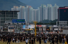 Protesters walk on a highway near Hong Kong's international airport following a protest against the police brutality and the controversial extradition bill on August 12, 2019. - Hong Kong airport authorities cancelled all remaining departing and arriving flights at the major travel hub on August 12, after thousands of protesters entered the arrivals hall to stage a demonstration. (Photo by Philip FONG / AFP)