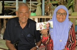 Abdulla Rafeeq and Aisaadhy hold up a photograph of themselves from their youth. PHOTO: HAWWA AMAANY ABDULLA / THE EDITION