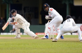 New Zealand's cricketer Henry Nicholls (L) watches as Sri Lankan cricketer Dhananjaya de Silva (R) takes a catch to dismiss him during the third day of the final cricket Test match between Sri Lanka and New Zealand at P. Sara Oval stadium in Colombo on August 24, 2019. (Photo by LAKRUWAN WANNIARACHCHI / AFP)