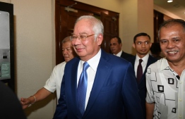 Malaysia's former prime minister Najib Razak (C) arrives at the High Court in Kuala Lumpur on August 28, 2019. - Malaysian ex-leader Najib Razak's most significant 1MDB trial begins on August 28, centring on allegations that hundreds of millions of dollars linked to the state fund ended up in his bank account. (Photo by Mohd RASFAN / AFP)