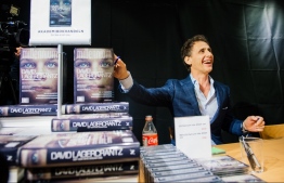 (FILES) In this file photo taken on August 28, 2015, the author of the fourth novel in the Millennium series of crime novels, originally by Stieg Larsson, The Girl in the Spider's Web, Swedish journalist and best-selling author, David Lagercrantz, signs the books for first buyers during a midnight sell at a local book store in Stockholm. - In "The Girl Who Lived Twice", Swedish crime writer Stieg Larsson's antiheroine Lisbeth Salander is back for the final instalment of the "Millennium" saga, which is hitting shelves in 47 countries. (Photo by Jonathan NACKSTRAND / AFP)