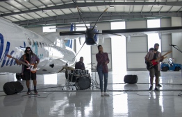 Brand ambassadors for Manta Air, Mariyam Maeesha (C) and Arshad Ali (Kokko Kabans) (R) perform 'Windwalker' during the music video shoot held inside the Dhaalu Airport hangar. PHOTO/MANTA AIR
