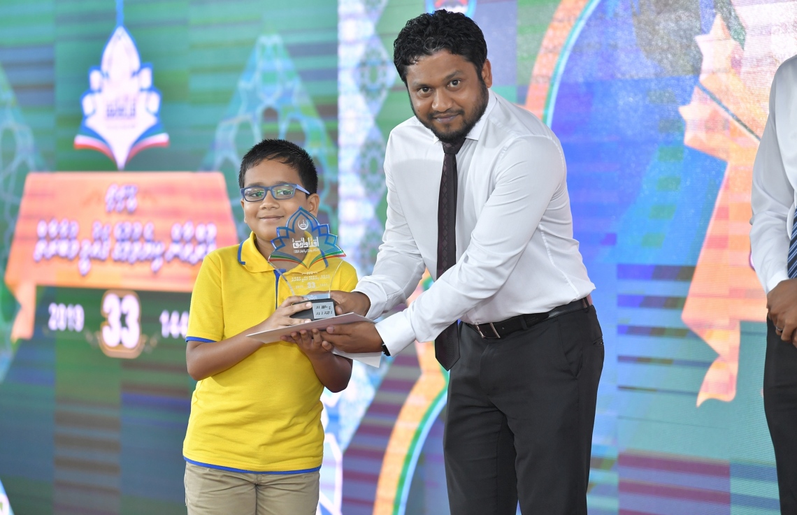 މާލެ: ސެޕްޓެމްބަރު 7، 2019: 33 ވަނަ ގައުމީ ގުރުއާން މުބާރާތުގެ ނަތީޖާ ފާޅުކުރުމަށް އިސްލާމީ މަރުކަޒުގައި ބޭއްވި ރަސްމިއްޔާތުގައި ރައީސް އޮފީހުގެ ޗީފް އޮފް ޕްރޮޓޮކޯލް އަލީ ޒާހިރު ދަރިވަރަކަށް އިނާމު ހަވާލު ކުރައްވަނީ.-- ފޮޓޯ: ރައީސް އޮފީސް