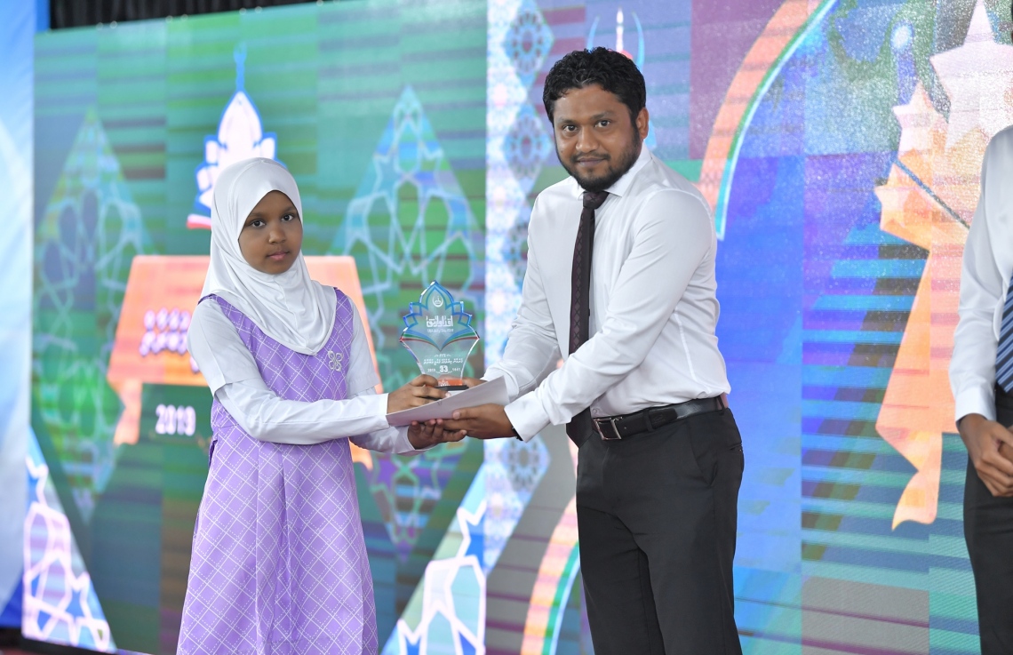 މާލެ: ސެޕްޓެމްބަރު 7، 2019: 33 ވަނަ ގައުމީ ގުރުއާން މުބާރާތުގެ ނަތީޖާ ފާޅުކުރުމަށް އިސްލާމީ މަރުކަޒުގައި ބޭއްވި ރަސްމިއްޔާތުގައި ރައީސް އޮފީހުގެ ޗީފް އޮފް ސްޓާފް އަލީ ޒާހިރު ދަރިވަރަކަށް އިނާމު ހަވާލު ކުރައްވަނީ.-- ފޮޓޯ: ރައީސް އޮފީސް