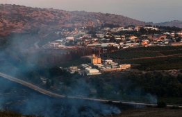 This picture taken on September 1, 2019 from a location near the southern Lebanese village of Maroun al-Ras, close to the border with Israel, shows smoke rising from fires along the border with Israel on the Lebanese side following an exchange of fire, with the northern Israeli town of Avivim in the background. - Israel and Hezbollah exchanged fire along the Lebanese border on September 1 after a week of rising tensions, but no casualties were reported following the brief flare-up and UN officials immediately urged restraint. (Photo by Mahmoud ZAYYAT / AFP)