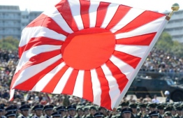 A soldier holds a Rising Sun flag during the military review at the Ground Self-Defence Force's Asaka training ground on October 27, 2013. PHOTO: GETTY IMAGES