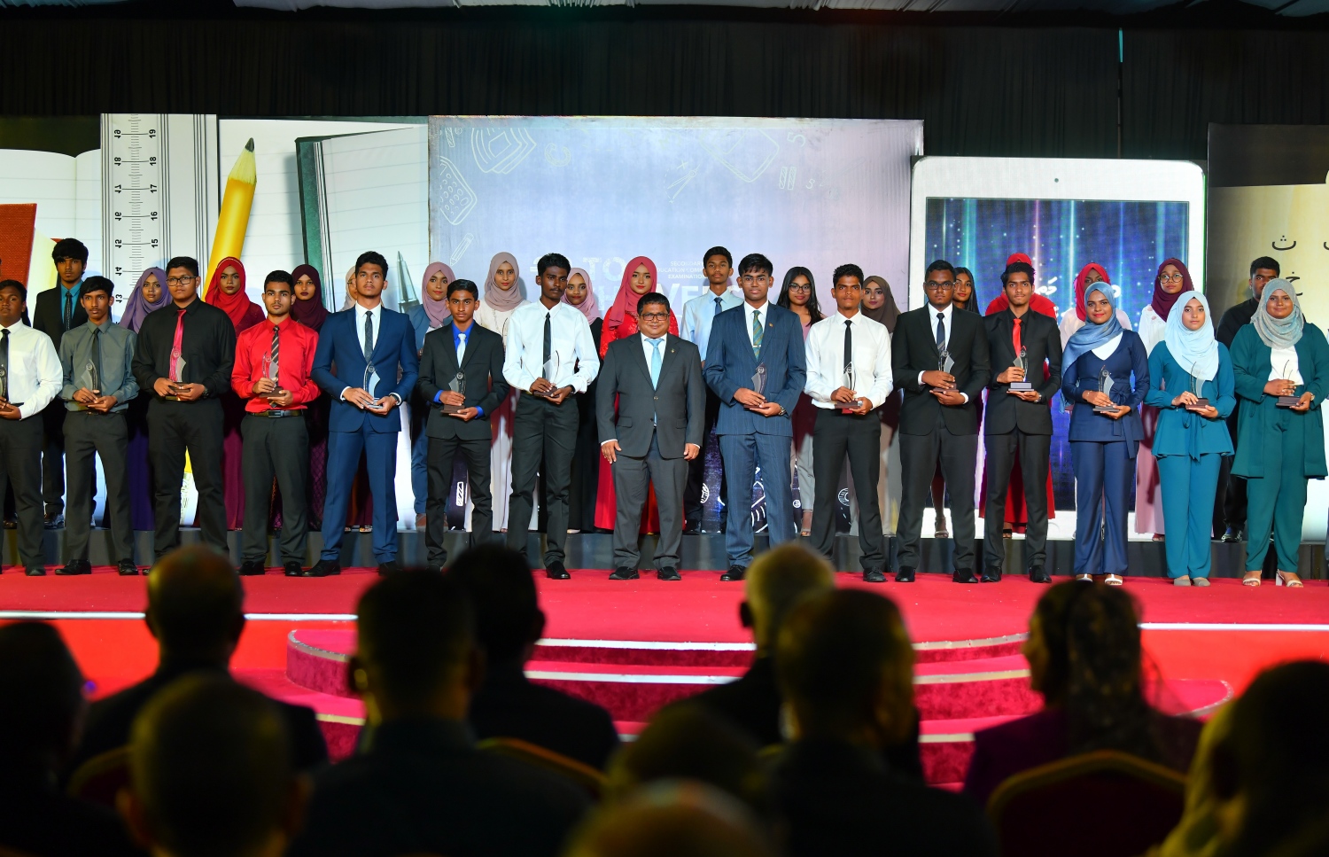 ސާނަވީ އިމްތިހާނުގައި ރާއްޖޭގެ ގަދަ 10ގައި ހިމެނުނު ދަރިވަރުންނަށް އިނާމު ދިނުމަށް ދަރުބާރުގޭގައި މީގެ ކުރިން ބޭއްވި ރަސްމިއްޔާތުގައި ފިޝަރީޒް މިނިސްޓަރު ޑރ. ހުސެއިން، ދަރިވަރުންތަކަކާ އެކު ފޮޓޯއަކަށް ހުއްޓިވަޑައިގެން---ފައިލް ފޮޓޯ: މިހާރު