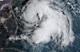 This satellite image obtained from NOAA/RAMMB, shows Tropical Storm Humberto as it moves near the Bahamas at 12:00UTC on September 15, 2019. - Tropical Storm Humberto lashed the Bahamas with rain and wind on September 14, 2019, possibly slowing down relief efforts in the wake of the devastation wrought less than two weeks ago by Hurricane Dorian.The US National Hurricane Center said the center of the storm, packing maximum sustained winds of 60 miles (95 kilometers) per hour, was passing Saturday evening about 85 miles north of Great Abaco Island, one of the areas hardest hit by Dorian. (Photo by HO / NOAA/RAMMB / AFP) / 