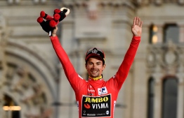 Team Jumbo rider Slovenia's Primoz Roglic celebrates on the podium with the leader's red jersey after winning the 2019 La Vuelta cycling Tour of Spain, at the end of the 21st and and last stage, a 106,6 km race from Fuenlabrada to Madrid on September 15, 2019. (Photo by OSCAR DEL POZO / AFP)