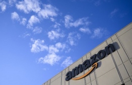 (FILES) In this file photo taken on February 5, 2019 the Amazon logo is viewed at the 855,000-square-foot Amazon fulfillment center in Staten Island, one of the five boroughs of New York City. - Amazon's latest innovation in the online payment world is something called... cash.The e-commerce giant said September 18, 2019 it was rolling out a cash payment option for US customers that has already been used in 19 other countries.The "Amazon PayCode" option is in partnership with the payments firm Western Union. (Photo by Johannes EISELE / AFP)