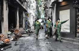 Employees of the Waste Management Corporation Limited (WAMCO) assisting the clearance of rubble and debris caused by the fire. PHOTO: HUSSAIN WAHEED / MIHAARU