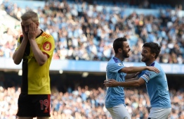 Manchester City's Portuguese midfielder Bernardo Silva (C) celebrates with Manchester City's Spanish midfielder David Silva (R) after he scores the team's seventh goal during the English Premier League football match between Manchester City and Watford at the Etihad Stadium in Manchester, north west England, on September 21, 2019. (Photo by Oli SCARFF / AFP) / RESTRICTED TO EDITORIAL USE. No use with unauthorized audio, video, data, fixture lists, club/league logos or 'live' services. Online in-match use limited to 120 images. An additional 40 images may be used in extra time. No video emulation. Social media in-match use limited to 120 images. An additional 40 images may be used in extra time. No use in betting publications, games or single club/league/player publications. / 