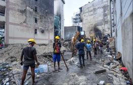 Workers clearing rubble from the site of the fire in the capital city of Male'. PHOTO: HUSSAIN WAHEED/ MIHAARU