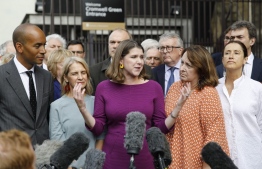 Britain's Liberal Democrat Party leader Jo Swinson (C) makes a statement to the press in front of her members of parliament outside one of the entrances to the Houses of Parliament in central London on September 25, 2019. - British MPs return to parliament on Wednesday following a momentous Supreme Court ruling that Prime Minister Boris Johnson's decision to suspend parliament was unlawful. (Photo by Tolga AKMEN / AFP)