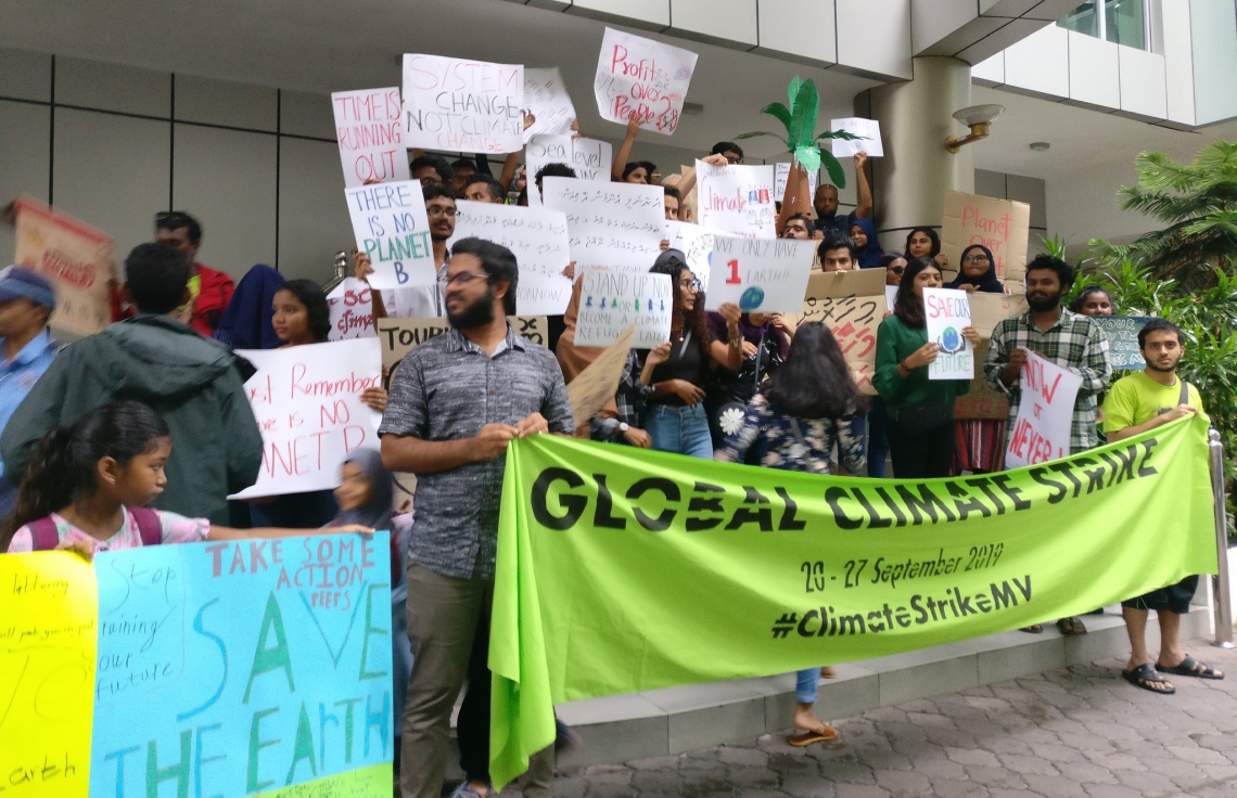 މާލެ: ސެޕްޓެމްބަރު 26، 2019: ތިމާވެއްޓަށް ދޭ ގެއްލުންތަކުން ދުނިޔެ ސަލާމަތް ކުރުމަށް ގޮވާލައި ކުރަމުންދާ ހަޅުތާލުގައި ބައިވެރިވި ކުދިންތަކެއް ތިމާވެށި ހިމާޔަތް ކޮށްދިނުމަށް ގޮވާލާ ހަދާފައިވާ ބޯޑްތަކެއް ހިފައިގެން.-- ފޮޓޯ: ސޭވް މޯލްޑިވްސް