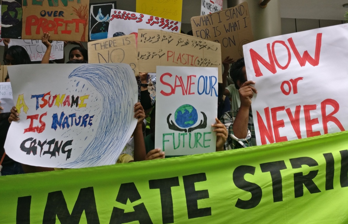 މާލެ: ސެޕްޓެމްބަރު 26، 2019: ތިމާވެއްޓަށް ދޭ ގެއްލުންތަކުން ދުނިޔެ ސަލާމަތް ކުރުމަށް ގޮވާލައި ކުރަމުންދާ ހަޅުތާލުގައި ބައިވެރިވި ކުދިންތަކެއް ތިމާވެށި ހިމާޔަތް ކޮށްދިނުމަށް ގޮވާލާ ހަދާފައިވާ ބޯޑްތަކެއް ހިފައިގެން.-- ފޮޓޯ: ސޭވް މޯލްޑިވްސް