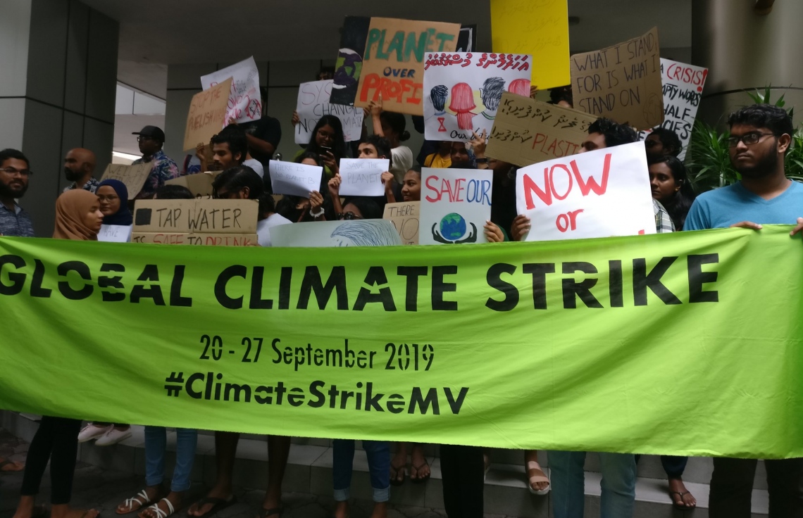 މާލެ: ސެޕްޓެމްބަރު 26، 2019: ތިމާވެއްޓަށް ދޭ ގެއްލުންތަކުން ދުނިޔެ ސަލާމަތް ކުރުމަށް ގޮވާލައި ކުރަމުންދާ ހަޅުތާލުގައި ބައިވެރިވި ކުދިންތަކެއް ތިމާވެށި ހިމާޔަތް ކޮށްދިނުމަށް ގޮވާލާ ހަދާފައިވާ ބޯޑްތަކެއް ހިފައިގެން.-- ފޮޓޯ: ސޭވް މޯލްޑިވްސް