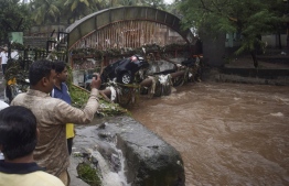 Onlookers and residents take photos of a car washed away by flash floods following heavy overnight rains in Pune on September 26, 2019. -  (Photo by Jignesh Mistry / AFP)