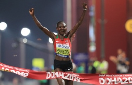 Kenya's Ruth Chepngetich celebrates after winning the Women's Marathon at the 2019 IAAF World Athletics Championships in Doha on September 27, 2019. (Photo by MUSTAFA ABUMUNES / AFP)