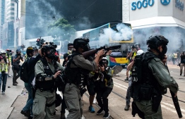 Hong Kong police fire tear gas to disperse protesters gathered in the Causeway Bay shopping district in Hong Kong on September 29, 2019. - Hong Kong descended into a second day of clashes between pro-democracy protesters and riot police on September 29 as activists step up their nearly four months campaign ahead of the 70th anniversary of communist China's founding. (Photo by Philip FONG / AFP)