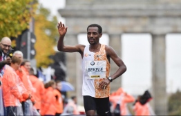 Ethiopia's Kenenisa Bekele performs a victory lap after winning the Berlin Marathon on September 29, 2019 in Berlin. (Photo by John MACDOUGALL / AFP)