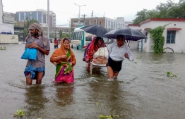 Patients wade through floodwaters on their way to hospital during heavy monsoon rain in Patna in the northeastern state of Bihar on September 28, 2019. (Photo by Sachin KUMAR / AFP)