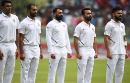 Indian cricket captain Virat Kohli (R) and teammates observe their national anthem on the first day of the first Test cricket match between India and South Africa in Visakhapatnam on October 2, 2019. (Photo by NOAH SEELAM / AFP) / 