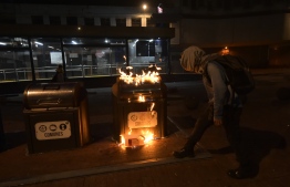 A demonstrators burns a trash bin in the street during a transport strike against the economic policies of the government of Ecuadorean President Lenin Moreno regarding the agreement signed on March with the International Monetary Fund (IMF), in Quito, on October 3, 2019. - The Ecuadorean government confirmed possible labour and tax reforms as established in the agreement, Economy Minister Richard Martinez stated -a day after announcing the elimination of fuel subsidies. (Photo by Rodrigo BUENDIA / AFP)