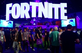 (FILES) In this file photo taken on June 12, 2018, people crowd the display area for the survival game Fortnite at the 24th Electronic Expo, or E3 2018, in Los Angeles, California. - The makers of online video gaming sensation Fortnite were accused on October 4, 2019, of designing it to be addictive, in a Canadian class action lawsuit likening playing to taking cocaine. Fortnite, released by US-based Epic Games in 2017, allows up to 100 players to fight individually or as part of a team to be the last standing on a virtual battlefield. It has become the most popular online game in the world, played by some 250 million people, including in tournaments with big cash prizes. (Photo by Frederic J. BROWN / AFP)
