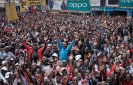 Kenyans watch a big screen on October 12, 2019, in Nairobi as they celebrate Kenya's Eliud Kipchoge victory. - Kenya's Eliud Kipchoge, on October 12, 2019, made history, busting the mythical two-hour barrier for the marathon on a specially prepared course in a huge Vienna park.
With an unofficial time of 1hr 59min 40.2sec, the Olympic champion became the first ever to run a marathon in under two hours in the Prater park with the course readied to make it as even as possible. (Photo by Yasuyoshi CHIBA / AFP)