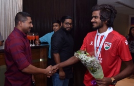 Minister of Youth, Sports and Community Development Ahmed Mahloof (L) and an athlete of the Under-18 National Football Team. PHOTO: FOOTBALL ASSOCIATION OF MALDIVES