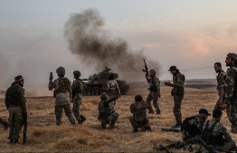 (FILES) In this file photo taken on October 14, 2019 Turkish soldiers and Turkey-backed Syrian fighters gather on the northern outskirts of the Syrian city of Manbij near the Turkish border as Turkey and its allies continue their assault on Kurdish-held border towns in northeastern Syria. (Photo by Zein Al RIFAI / AFP)