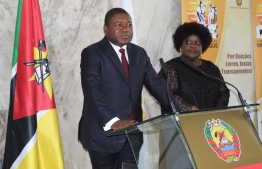 Mozambican President Felipe Nyusi(L) speaks as his wife Isaura(R) listens after casting their ballots at the Jozina Machel school during the Mozambican General Elections on October 15, 2019 in Maputo, Mozambique. (Photo by Robert Paquete / AFP)