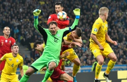 Ukraine's goalkeeper Andriy Pyatov and Portugal's forward Cristiano Ronaldo in action during the Euro 2020 football qualification match between Ukraine and Portugal at the NSK Olimpiyskyi stadium in Kiev on October 14, 2019. (Photo by GENYA SAVILOV / AFP)