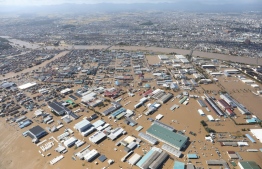 This aerial view shows a flooded area besides the Abukuma river in Koriyama, Fukushima prefecture on October 13, 2019, one day after Typhoon Hagibis swept through central and eastern Japan. - At least 15 people are dead and nine others missing, officials said on October 13, a day after powerful Typhoon Hagibis slammed into Japan, unleashing "unprecedented" rain and catastrophic flooding. (Photo by STR / JIJI PRESS / AFP) / 