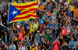 Pro independence protesters march in San Vicenc dels Horts, on October 18, 2019, on the day that separatists have called a general strike and a mass rally. - Catalan separatists burned barricades and clashed with police in Barcelona yesterday in a fourth night of violence triggered by Spain's jailing of nine of their leaders over a failed independence bid while today they have blocked traffic on two routes connecting Spain and France, on the fifth day of protests, the transport ministry said Friday. (Photo by Pau Barrena / AFP)