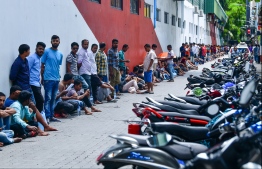 Expatriate workers queue up at the National Football Stadium in Male' for re-registration. FILE PHOTO: HUSSAIN WAHEED / MIHAARU