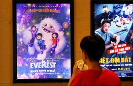 A boy looks at a poster for the animated movie "Everest Nguoi Tuyet Be Nho", also known as "Abominable", at a movie theatre in Hanoi on October 14, 2019. - Vietnam has pulled the animated film "Abominable" from theatres over a scene featuring a map of the South China Sea showing Beijing's claims in the flashpoint waterway, state media reported on October 14. (Photo by Nhac NGUYEN / AFP)