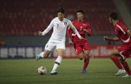This handout photo taken on October 15, 2019 by the Korea Football Association (KFA) shows South Korea's Son Heung-min (L) and North Korea's Han Kwang Song (C) fighting for the ball during the World Cup 2022 Qualifying Asian zone Group H football match between South Korea and North Korea at Kim Il Sung Stadium in Pyongyang. North and South Korea drew 0-0 in a historic but surreal World Cup qualifier on October 15, played in front of an empty stadium and almost completely blocked off from the outside world.
handout / Korea Football Association / AFP