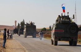 A convoy of Russian military vehicles drives toward the northeastern Syrian city of Kobane on October 23, 2019. - Russian forces in Syria headed for the border with Turkey today to ensure Kurdish fighters pull back after a deal between Moscow and Ankara wrested control of the Kurds' entire heartland. (Photo by - / AFP)