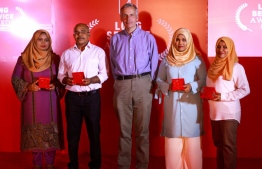 Bank of Maldives (BML) CEO and MD Tim Sawyer posing for a picture for employees that served the bank for 30 years. PHOTO: BML