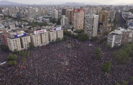 In this aerial view thousands of people protest in Santiago, on October 25, 2019, a week after violent protests started. - Demonstrations against a hike in metro ticket prices in Chile's capital exploded into violence on October 18, unleashing widening protests over living costs and social inequality. (Photo by Pedro Ugarte / AFP)