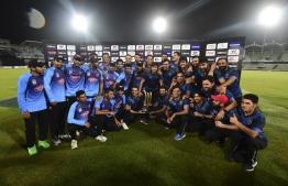 (FILES) In this file photo taken on September 24, 2019 Bangladesh and Afghanistan cricketers pose for a photo with the tournament trophy after the match was abandoned for rainfall during the final Twenty20 international match of a tri-nation series between Afghanistan and Bangladesh at the Sher-e-Bangla National Stadium in Dhak. - Cricketers in Bangladesh's main domestic league will see match payments almost double under a new deal that ended a player strike last week, the sport's ruling body said on October 28. Players in the top-tier of the National Cricket League will receive 60,000 taka ($705) instead of 35,000 taka per four-day match, a Bangladesh Cricket Board (BCB) statement said (Photo by MUNIR UZ ZAMAN / AFP)