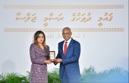 A family member accepts the National Award of Honour conferred posthumously on the late Sayyid Hassan, for his contributions in the area of sports in sportsmanship and sports development. PHOTO: HUSSAIN WAHEED / MIHAARU