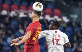 AS Roma's Italian defender Leonardo Spinazzola (L) jumps for the ball with AC Milan's Portuguese forward Rafael Leao, during the Italian Serie A football match between AS Roma and AC Milan, on October 27, 2019 at the Olympic stadium in Rome. (Photo by Andreas SOLARO / AFP)