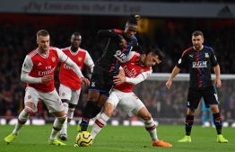 Crystal Palace's Ivorian striker Wilfried Zaha (C) vies with Arsenal's Swiss midfielder Granit Xhaka (2nd R) during the English Premier League football match between Arsenal and Crystal Palace at the Emirates Stadium in London on October 27, 2019. (Photo by DANIEL LEAL-OLIVAS / AFP) / RESTRICTED TO EDITORIAL USE. No use with unauthorized audio, video, data, fixture lists, club/league logos or 'live' services. Online in-match use limited to 120 images. An additional 40 images may be used in extra time. No video emulation. Social media in-match use limited to 120 images. An additional 40 images may be used in extra time. No use in betting publications, games or single club/league/player publications. / 
