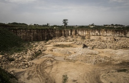 A large rock quarry that feeds a cement factory is seen on the outskirts of Bandia Forest on September 25, 2019. - The need for cement in a growing Dakar means that quarries are need to feed the factories, these quarries are moving closer to villages and threatening Bandia Forest. (Photo by JOHN WESSELS / AFP)