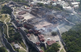 This aerial picture shows the Shuri Castle after a fire ripped through the historic site in Naha, Okinawa prefecture, southern Japan on October 31, 2019. - A fire ripped through the ancient Japanese Shuri castle on the southern island of Okinawa early on October 31, spreading throughout the historic World Heritage site's complex, local authorities said. (Photo by STR / JIJI PRESS / AFP) / 